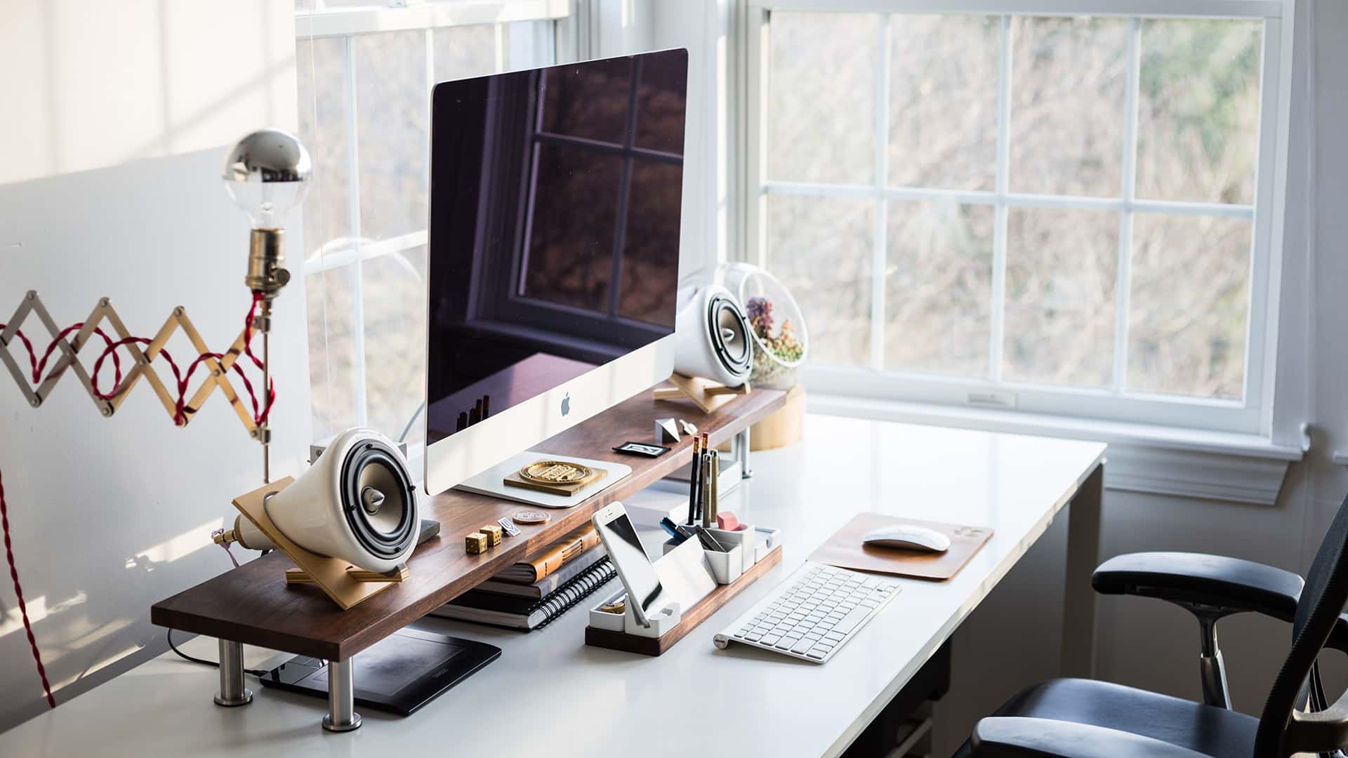 Bureau design et bien décoré avec un ordinateur sur élevé par un support en bois